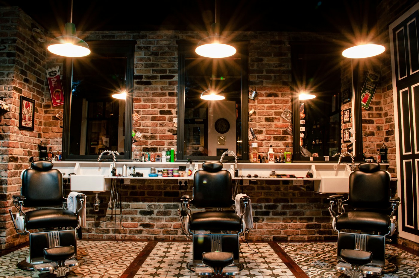 Classic barbershop with leather chairs, mirrors, and a brick wall